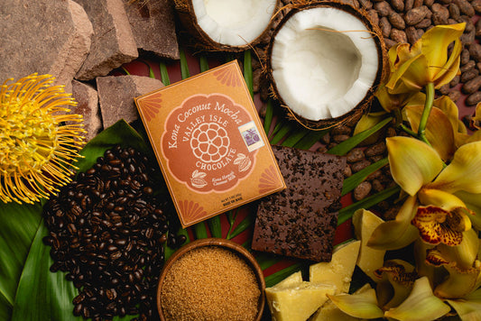 Box of Kona Coconut Mocha chocolate on a decorative background with coconuts, coffee beans, and flowers.