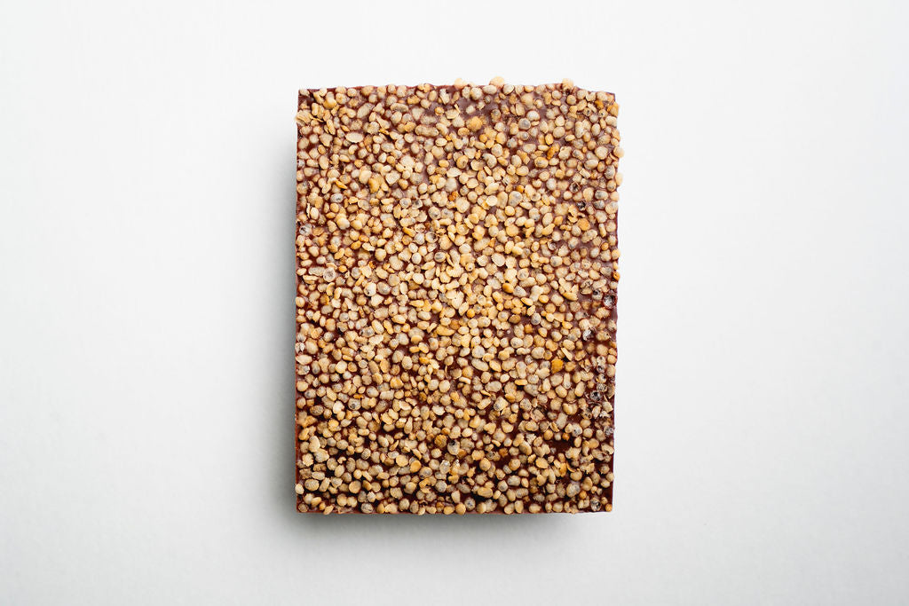 Rectangular milk chocolate with a textured quinoa surface on a white background