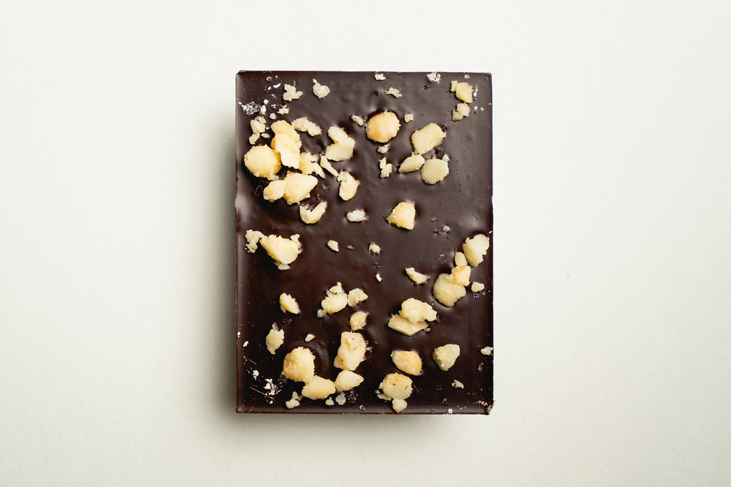 Chocolate bar with macadamia pieces on a light background