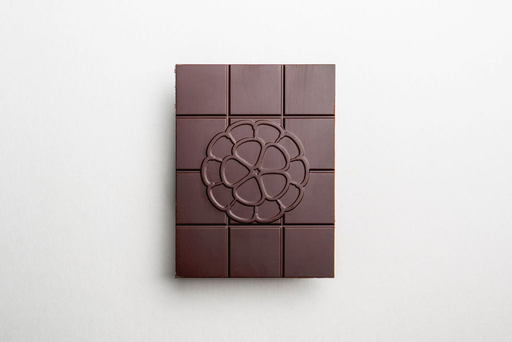 Dark chocolate bar with a floral design on a white background